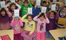 Fröhliche Grundschulkinder nach der Bücherübergabe